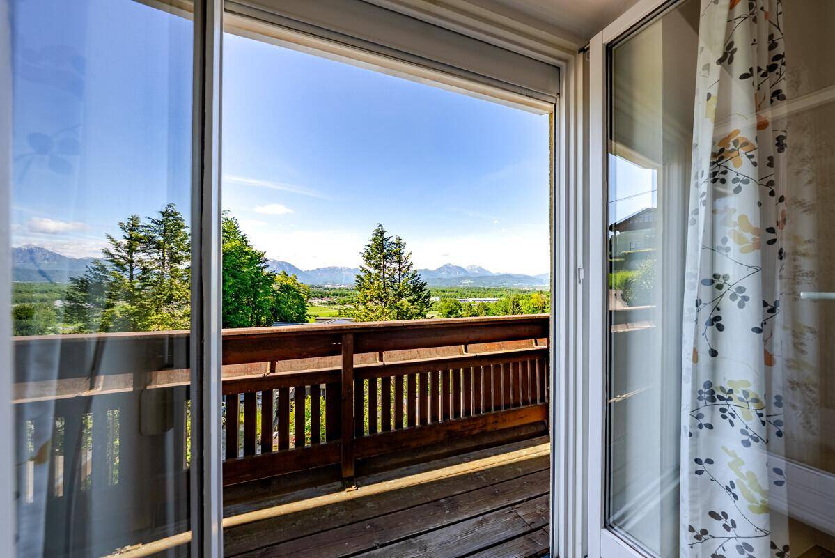 Heller Innenraum mit Zugang zum Balkon, der einen weiten Blick auf die Berge bietet.