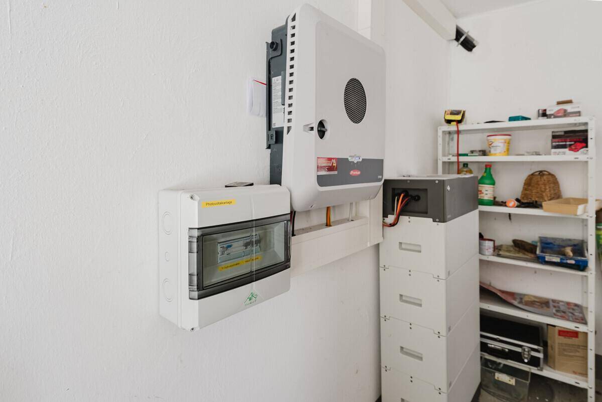 Technikraum mit Photovoltaik-Wechselrichter und Batteriespeicher an der Wand.