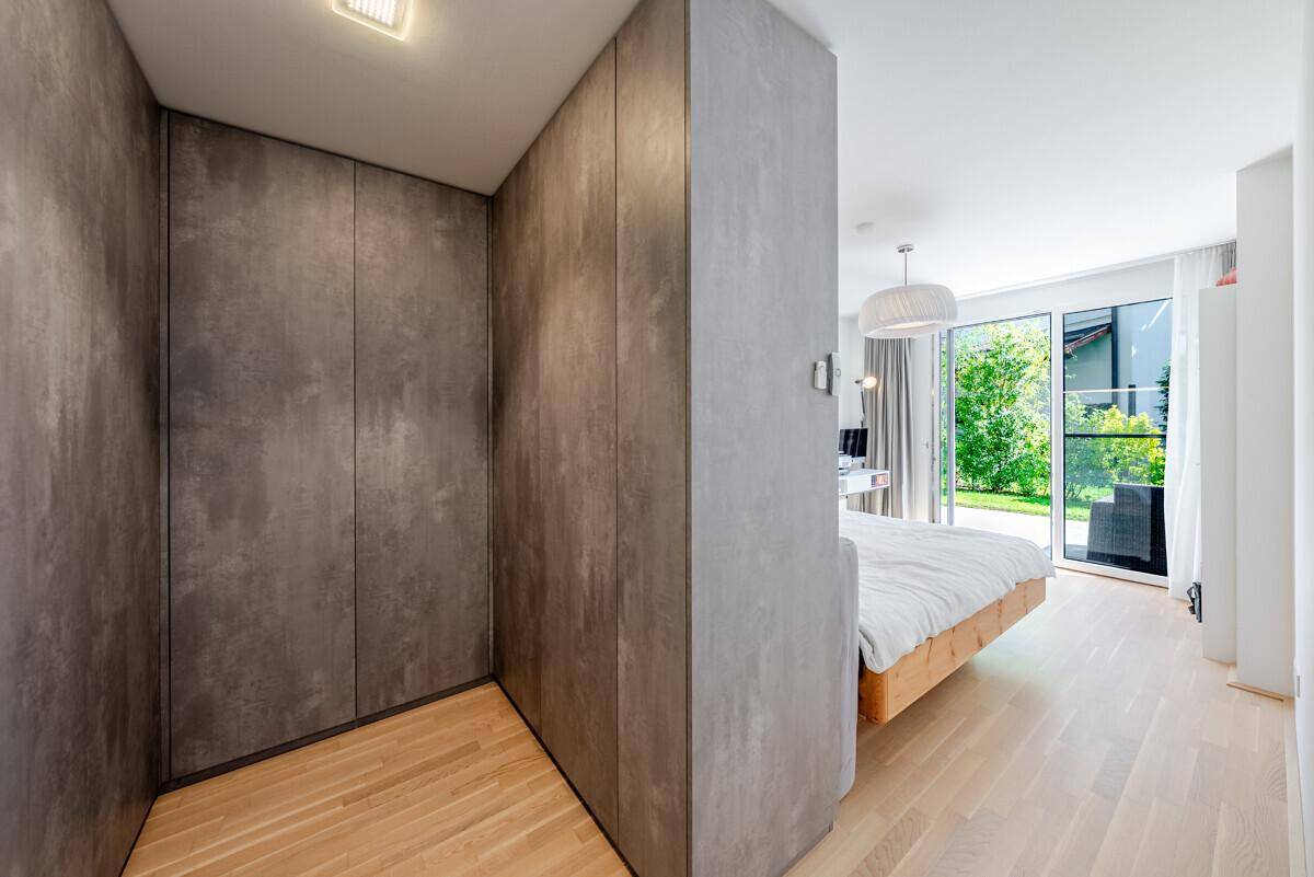 Moderner Flur mit integrierten Schränken und hellem Holzboden, der zum Schlafzimmer führt.