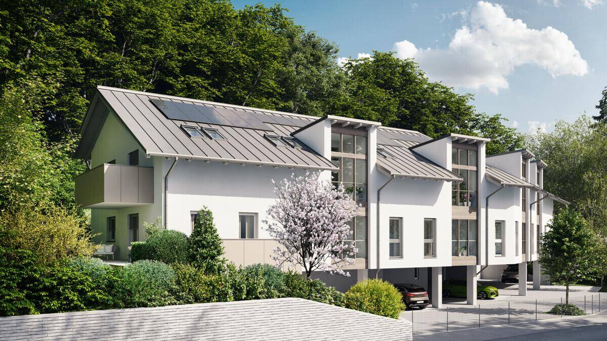 Attraktives Mehrfamilienhaus mit moderner Architektur, Balkonen und Photovoltaikanlage auf dem Dach.