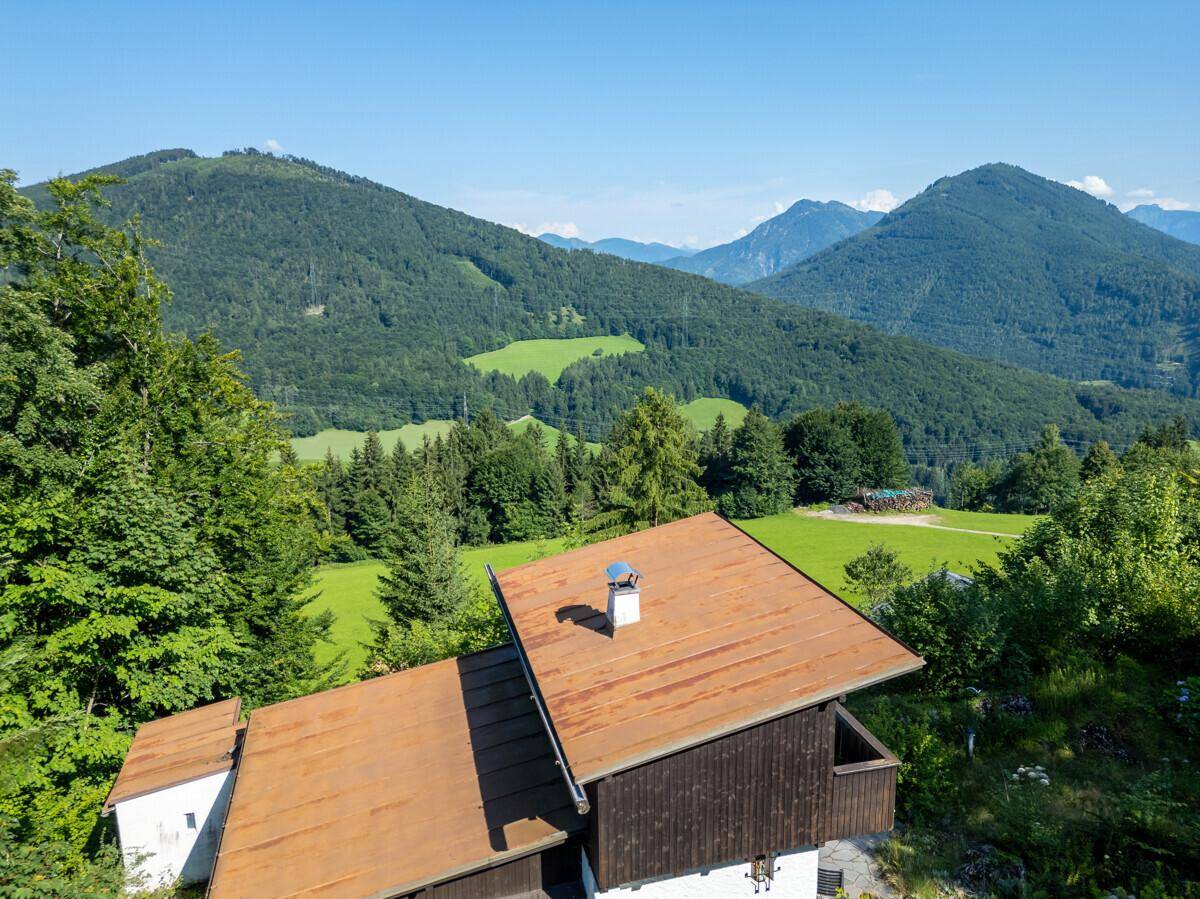 Dachansicht des Hauses mit braunem Dach und weitem Blick auf die umliegende Berglandschaft.