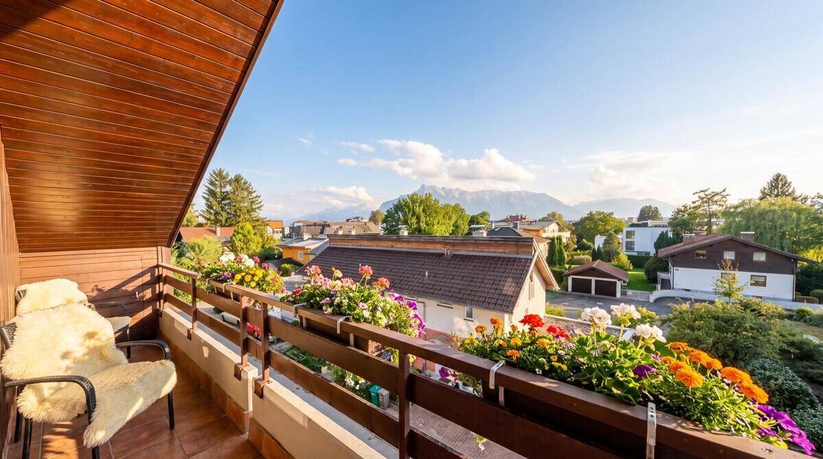 Balkon mit bunten Blumenkästen und einem malerischen Blick auf die umliegende Berglandschaft.