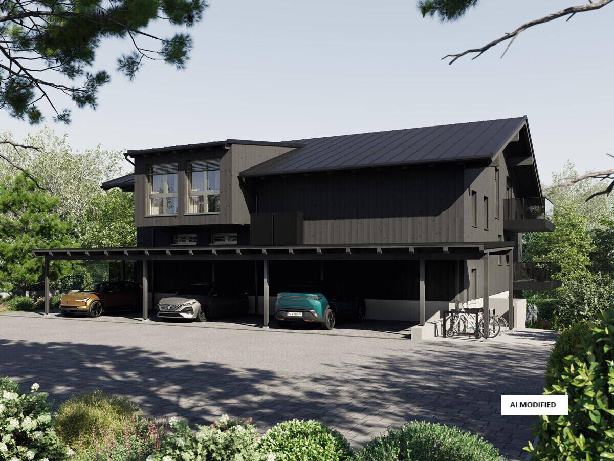 Modernes Haus mit dunkler Holzfassade und überdachtem Carport für mehrere Fahrzeuge.