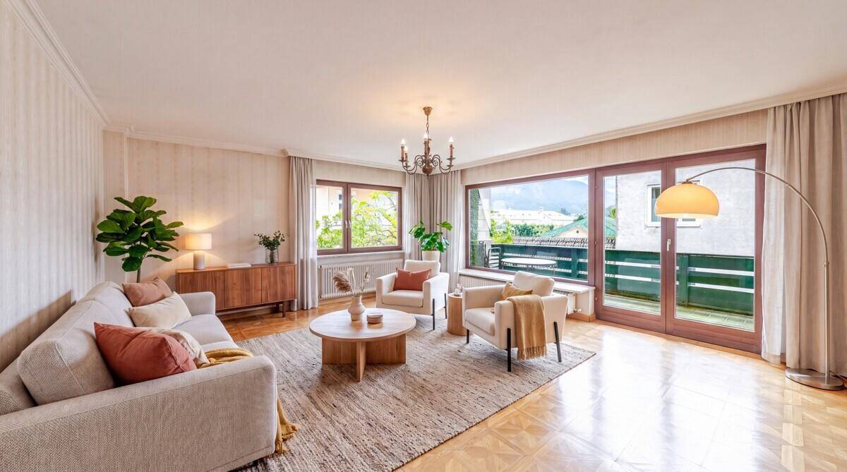 Helles Wohnzimmer mit Parkettboden, bequemen Sofas und Zugang zum Balkon.