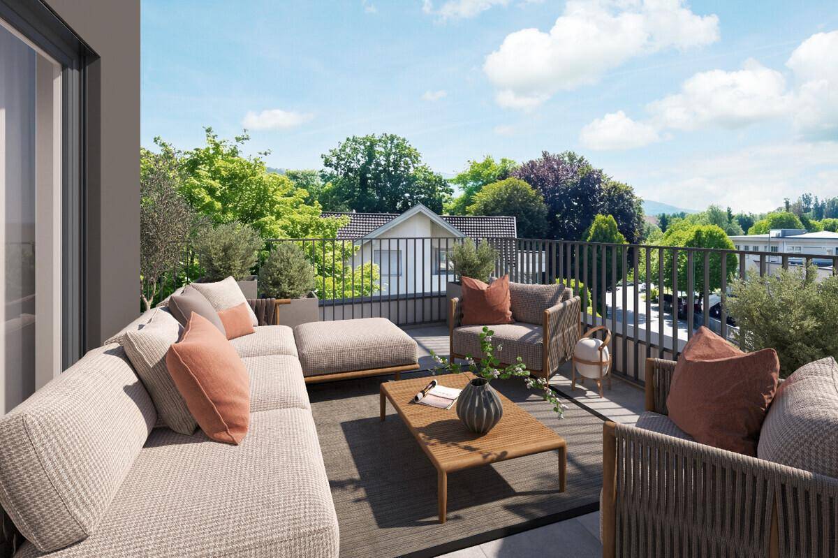 Sonnige Terrasse mit bequemen Lounge-Möbeln und Blick ins Grüne.