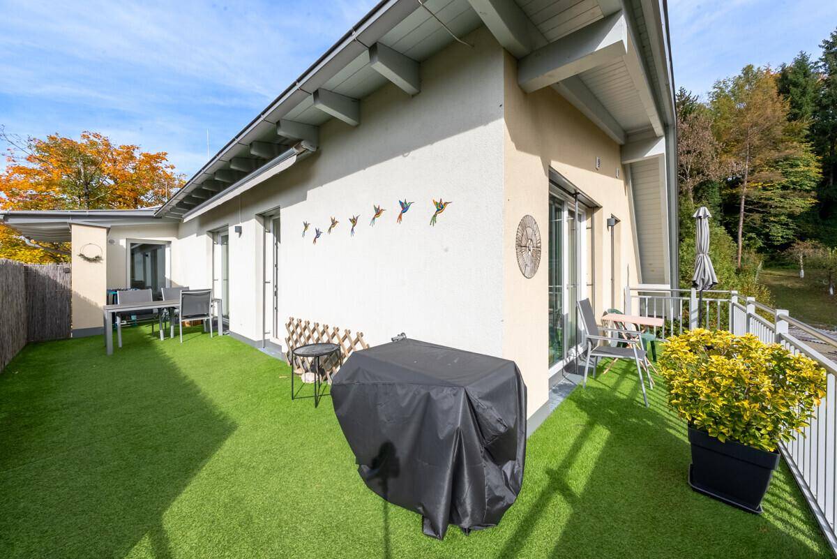 Geräumige Terrasse mit Kunstrasen, Grillbereich und Sitzgelegenheiten für entspannte Stunden im Freien.