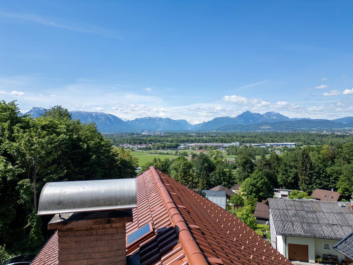 Dachansicht mit Ziegeln und Dachfenstern, bietet einen weiten Blick auf die Berglandschaft.