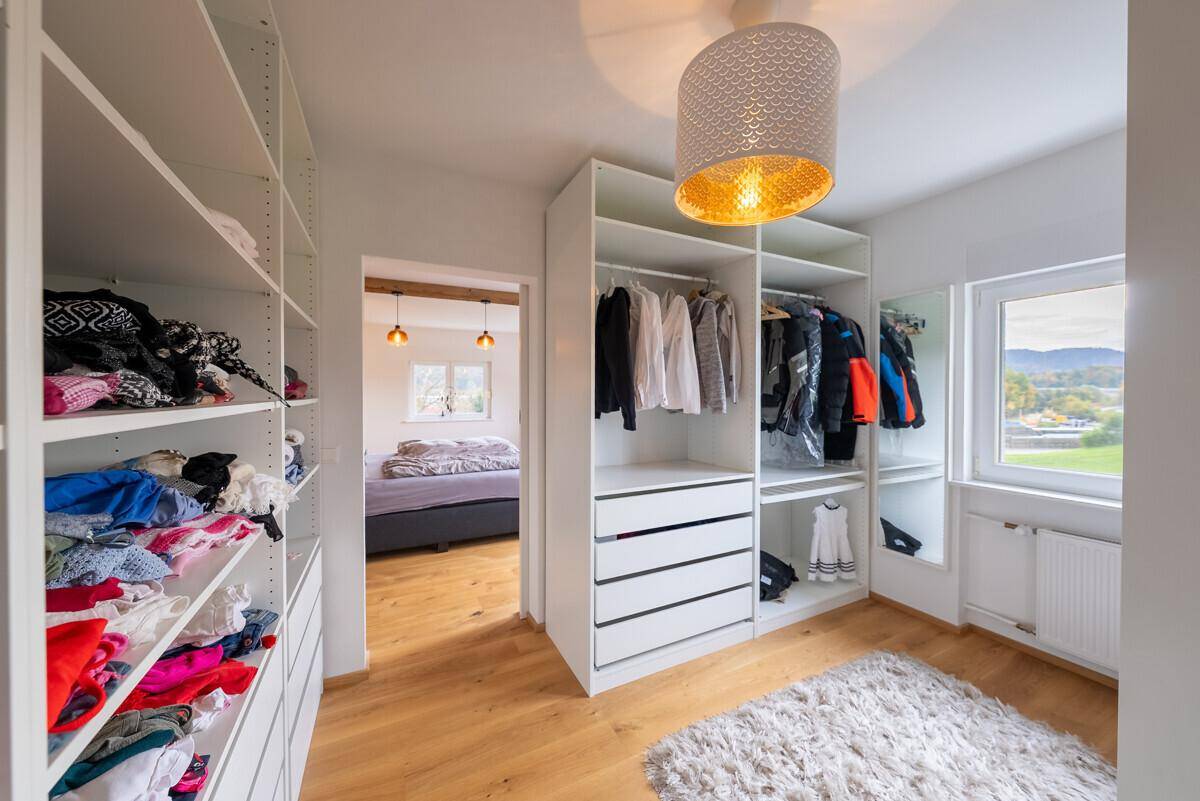 Begehbarer Kleiderschrank mit offenen Regalen und viel Stauraum, direkt vom Schlafzimmer zugänglich.