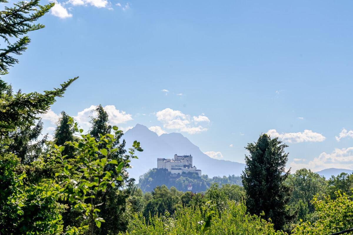 Panoramablick auf die majestätische Festung Hohensalzburg und die umliegende Berglandschaft.