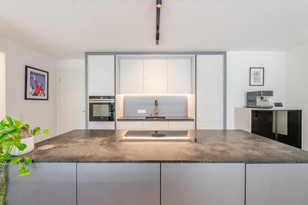 Hochwertige Einbauküche mit modernen Geräten, integriertem Backofen und Kaffeemaschine.