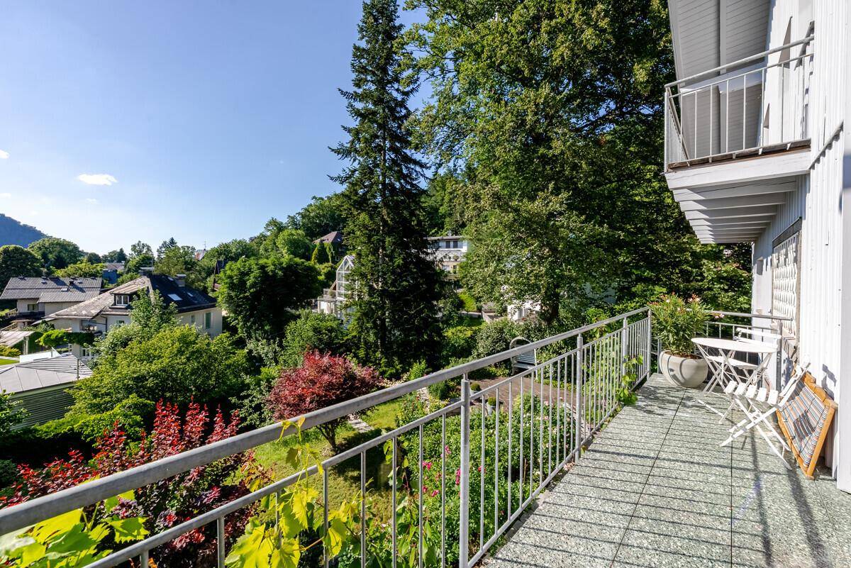 Langer Balkon mit Metallgeländer und Sitzgelegenheiten, bietet einen weiten Blick ins Grüne.