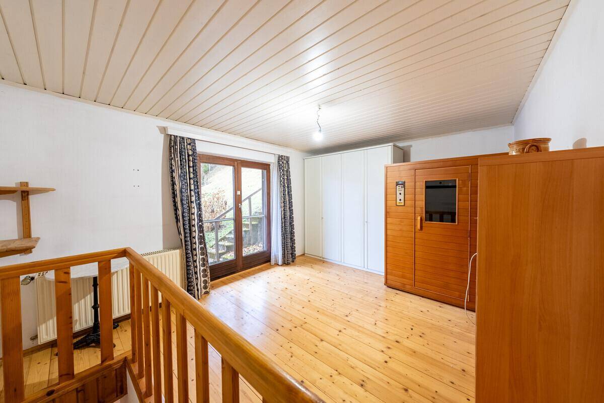 Geräumiger Raum mit Holzfußboden, Einbauschränken und einer privaten Sauna für Wellnessmomente.
