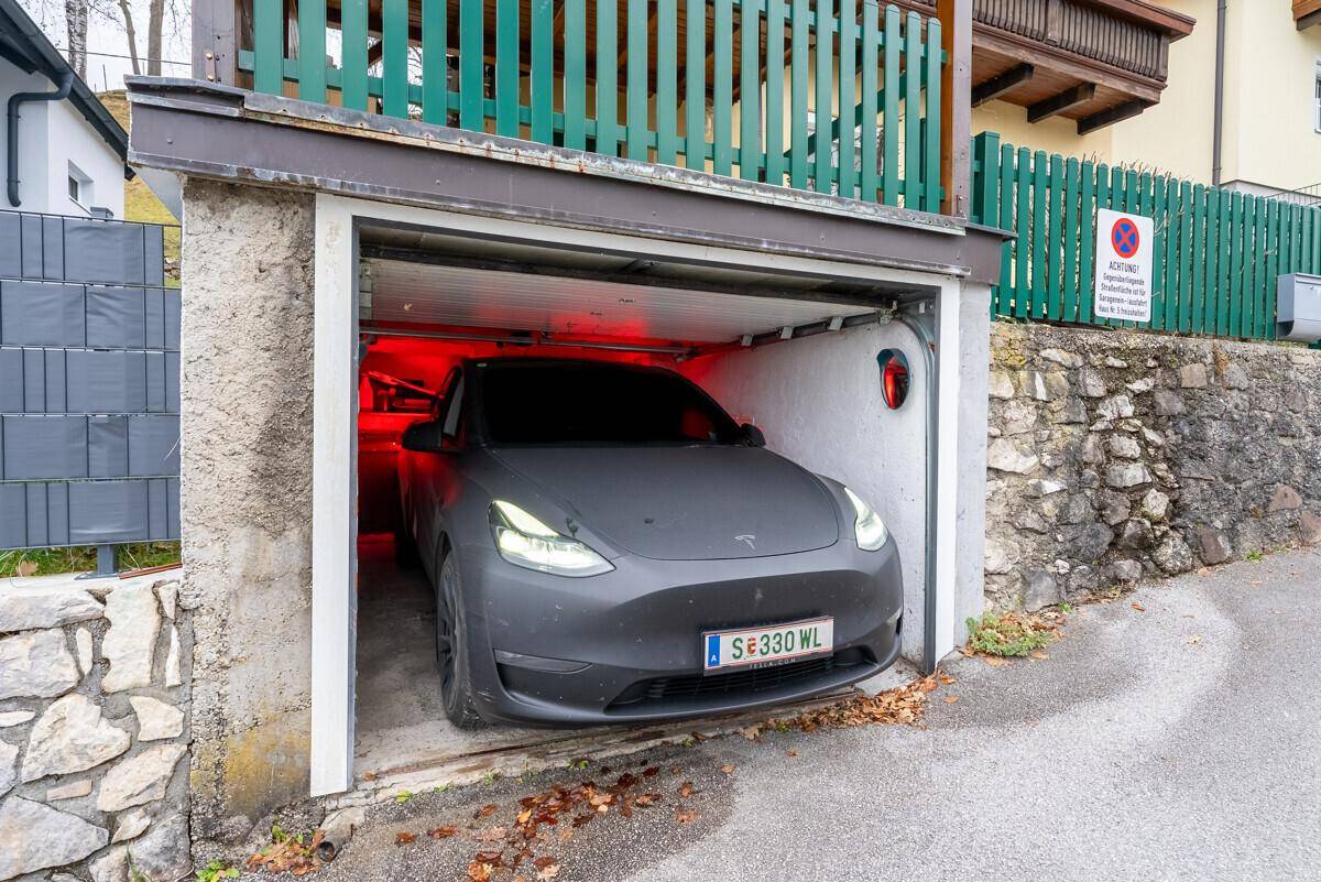 Einzelgarage mit einem modernen Elektrofahrzeug, bietet sicheren Parkplatz.