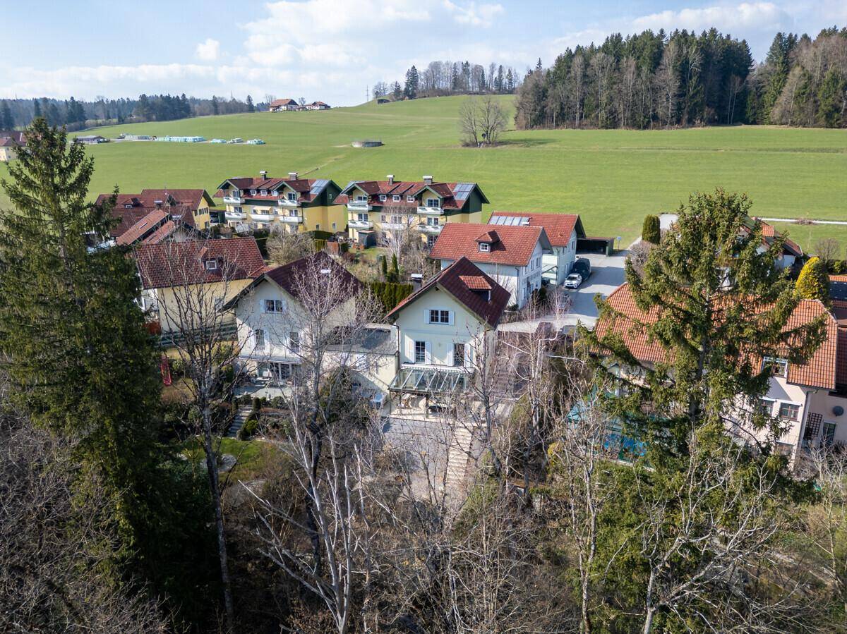 Luftaufnahme einer Wohnsiedlung mit Einfamilienhäusern und weiten Grünflächen.