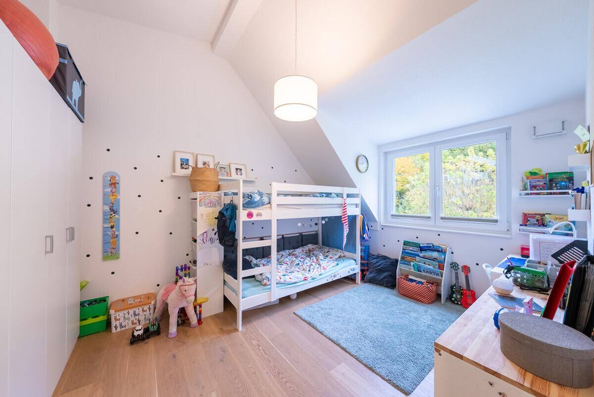 Helles Kinderzimmer mit Etagenbett, Holzboden und viel Platz zum Spielen.