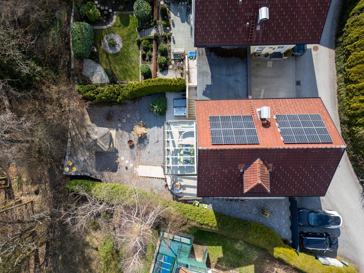 Vogelperspektive eines Hauses mit Satteldach, Photovoltaikanlage und Garten.