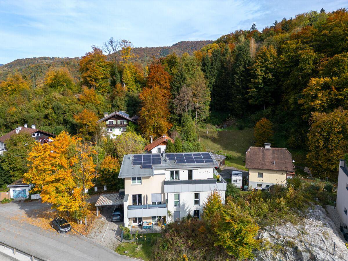 Weitläufige Luftaufnahme des Anwesens mit Photovoltaikanlage und der umliegenden herbstlichen Landschaft.