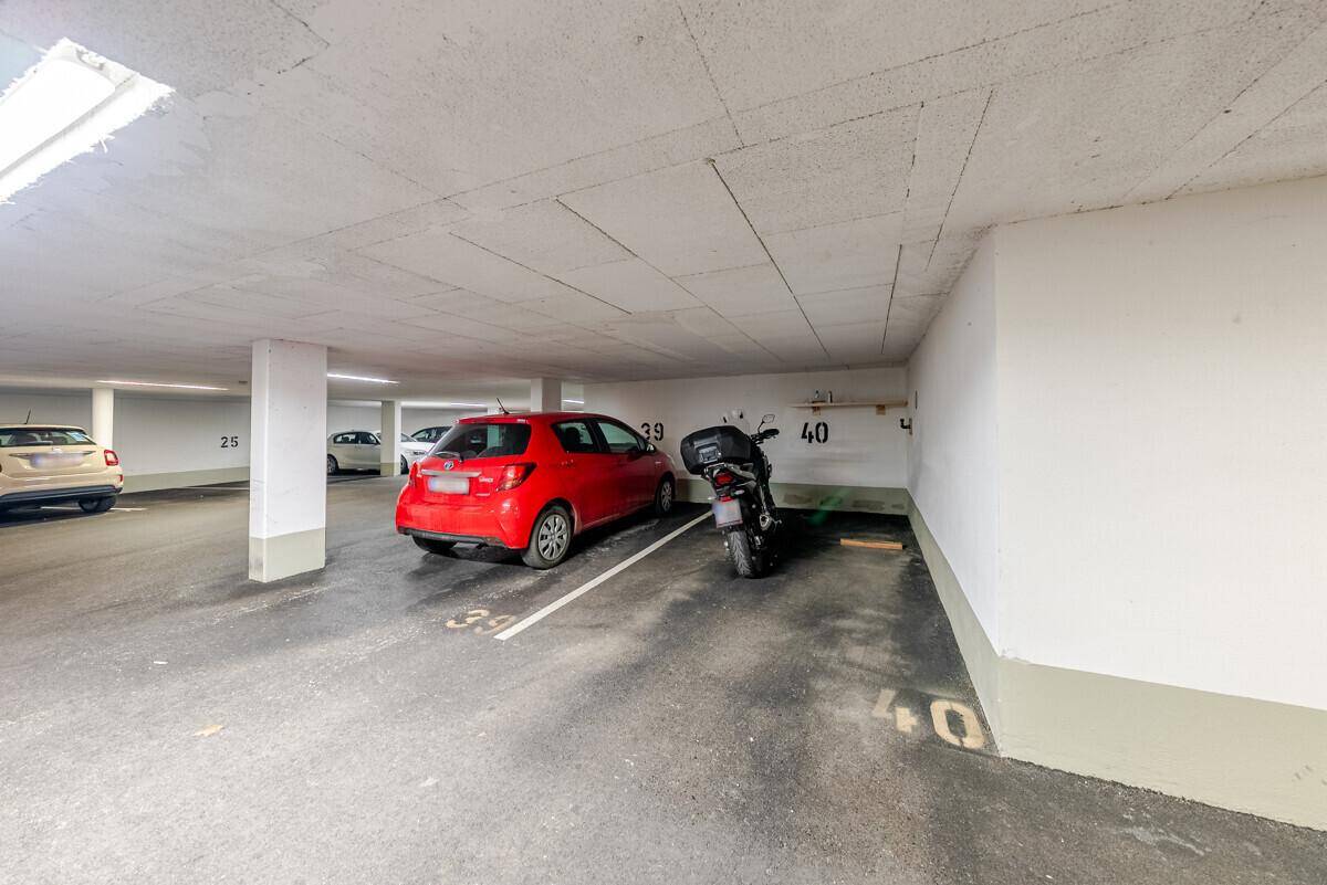 Tiefgarage mit markierten Stellplätzen und geparkten Fahrzeugen.