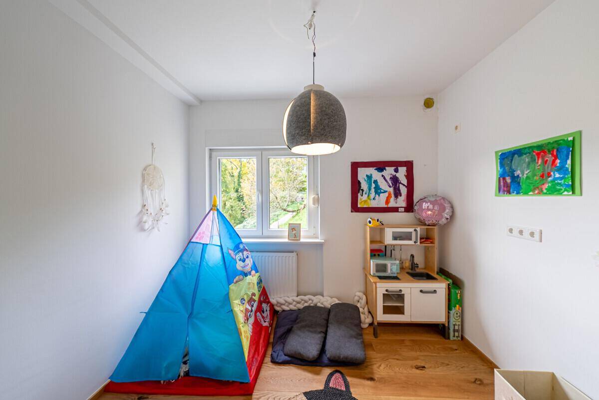 Kinderzimmer mit Spielzelt und kleiner Spielküche, hell und freundlich gestaltet.