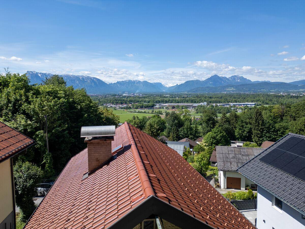 Dachansicht mit Ziegeln und Schornstein, bietet einen weiten Blick auf die Berglandschaft.
