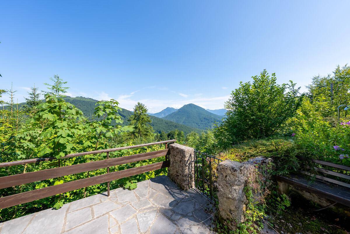 Detailansicht der Terrasse mit Steinbrüstung und atemberaubendem Panoramablick auf die Berge.
