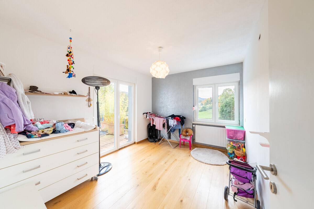 Kinderzimmer mit Wickelkommode und Zugang zu einem Balkon, hell und funktional eingerichtet.