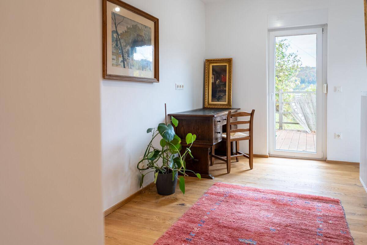 Kleiner Arbeitsbereich mit Holzboden und Zugang zu einem Balkon mit Weitblick.