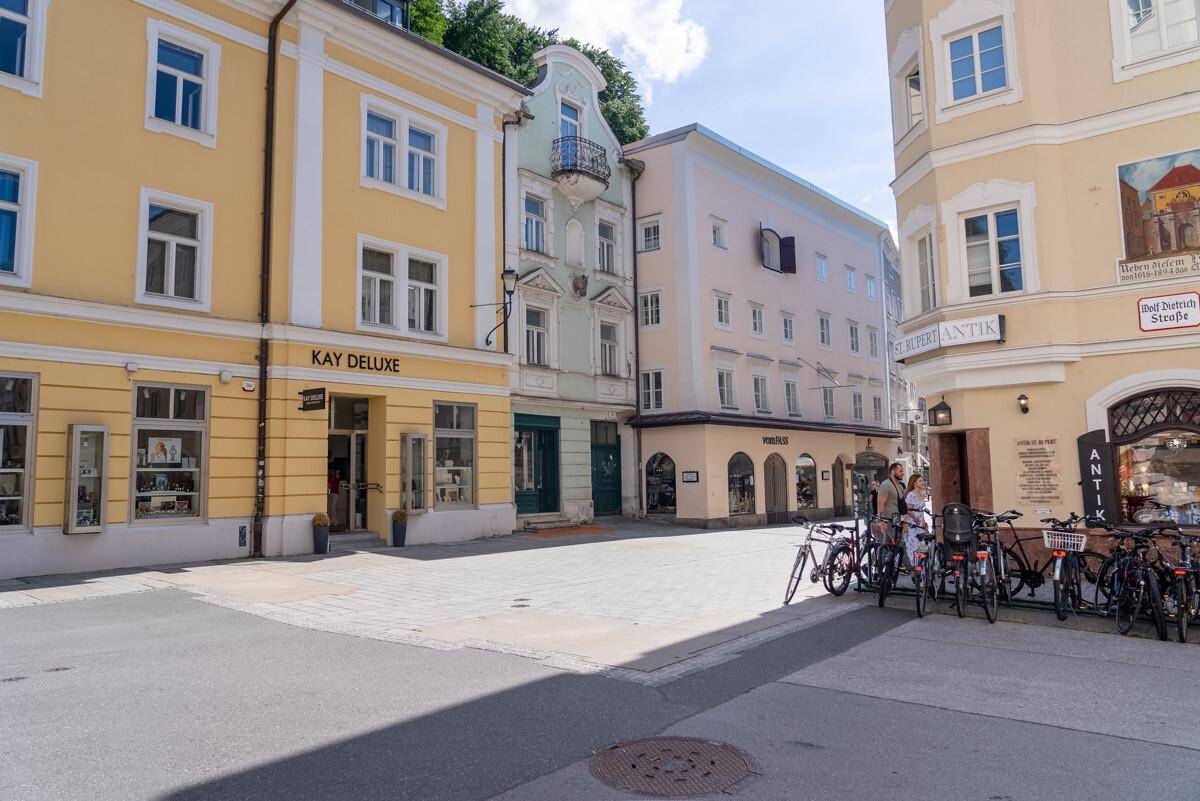 Historische Straßenecke mit charmanten Gebäuden, Geschäften und Fahrrädern in einer belebten Stadt.
