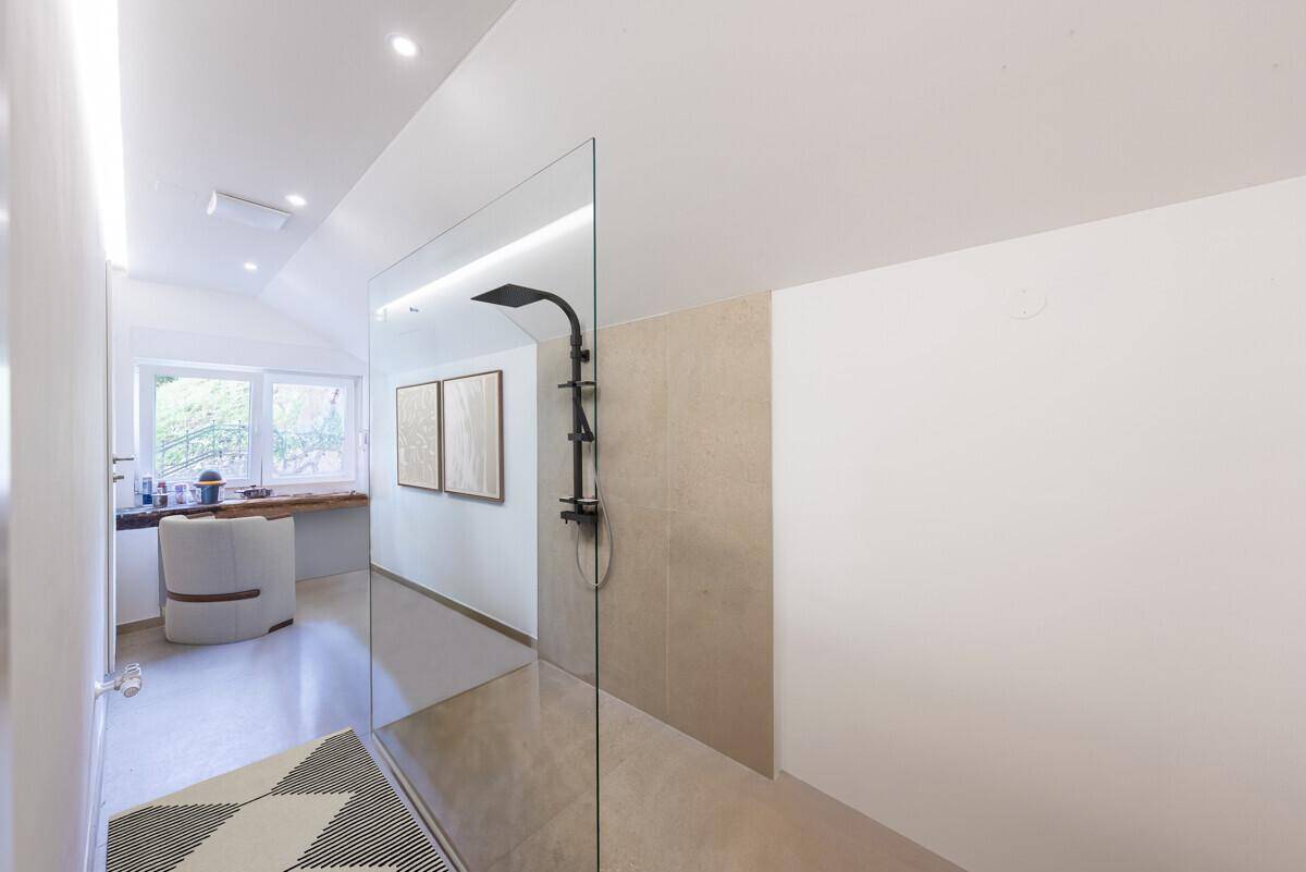 Geräumiges Badezimmer mit begehbarer Dusche und minimalistischem Design, hell und modern.