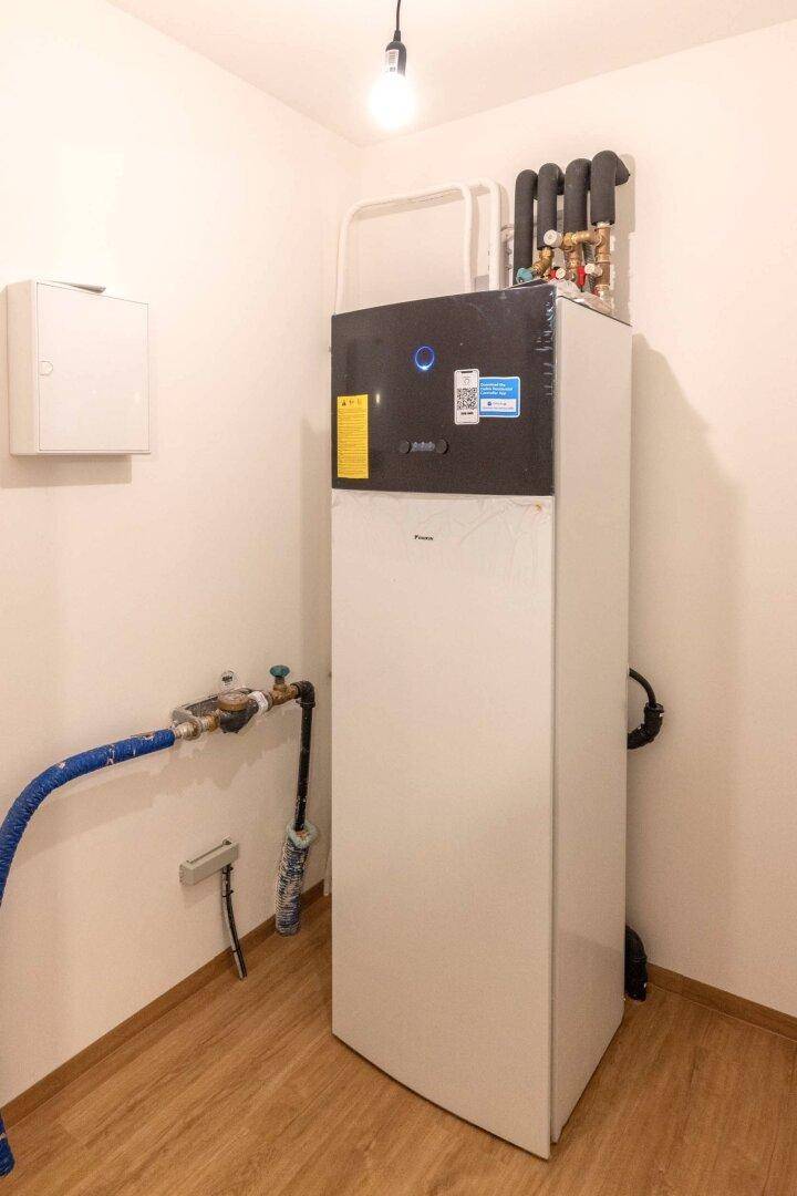 Hauswirtschaftsraum mit moderner Wärmepumpe und Anschlüssen.