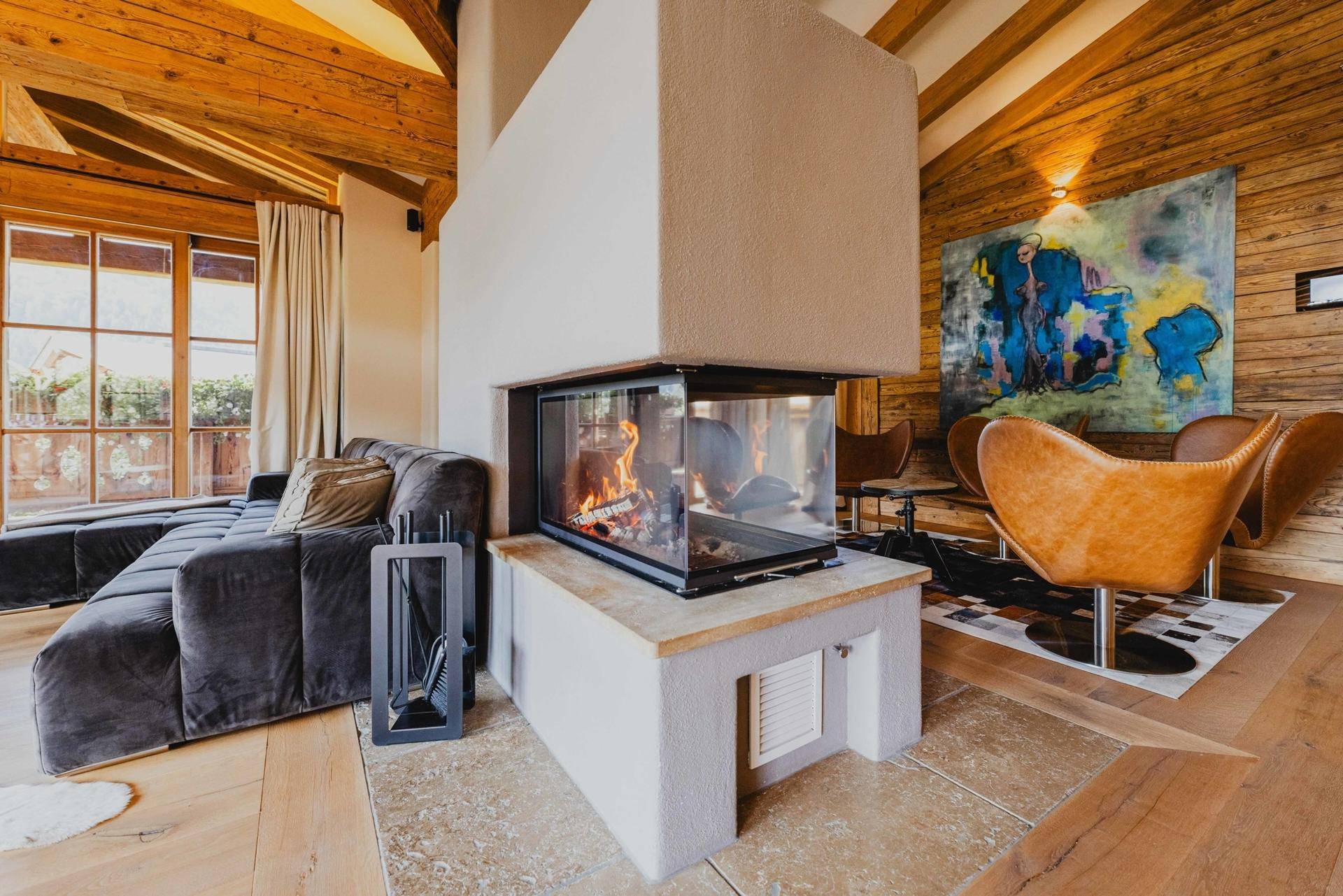 Gemütlicher Wohnbereich mit modernem Kamin, bequemen Sofas und Kunstwerken an der Wand.