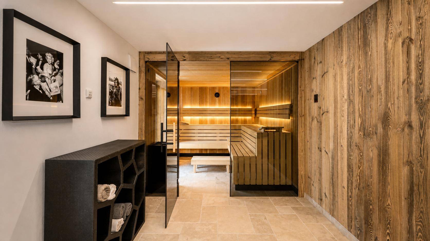 Exklusiver Wellnessbereich mit moderner Sauna, Holzwänden und Fliesenboden.