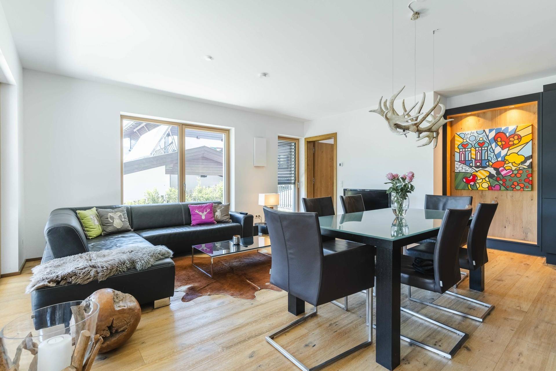 Gemütlicher Wohnbereich mit Ecksofa, Holzboden und Blick auf die moderne Einrichtung.