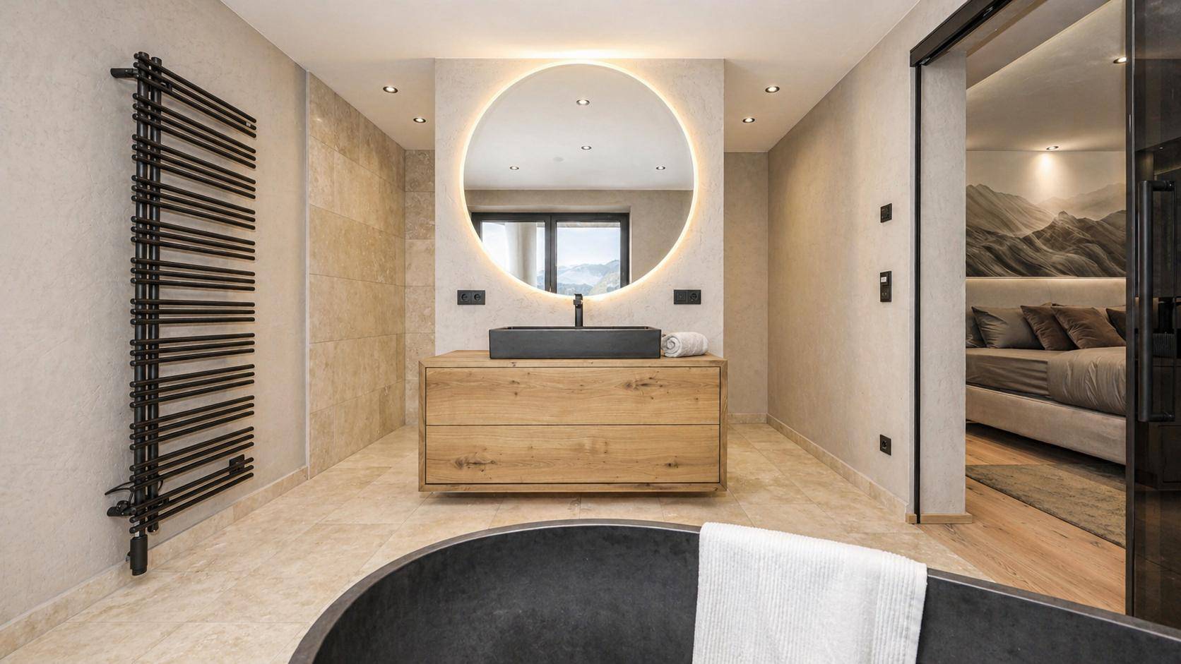 Modernes Badezimmer mit freistehender schwarzer Badewanne, Holzwaschtisch und beleuchtetem Spiegel.