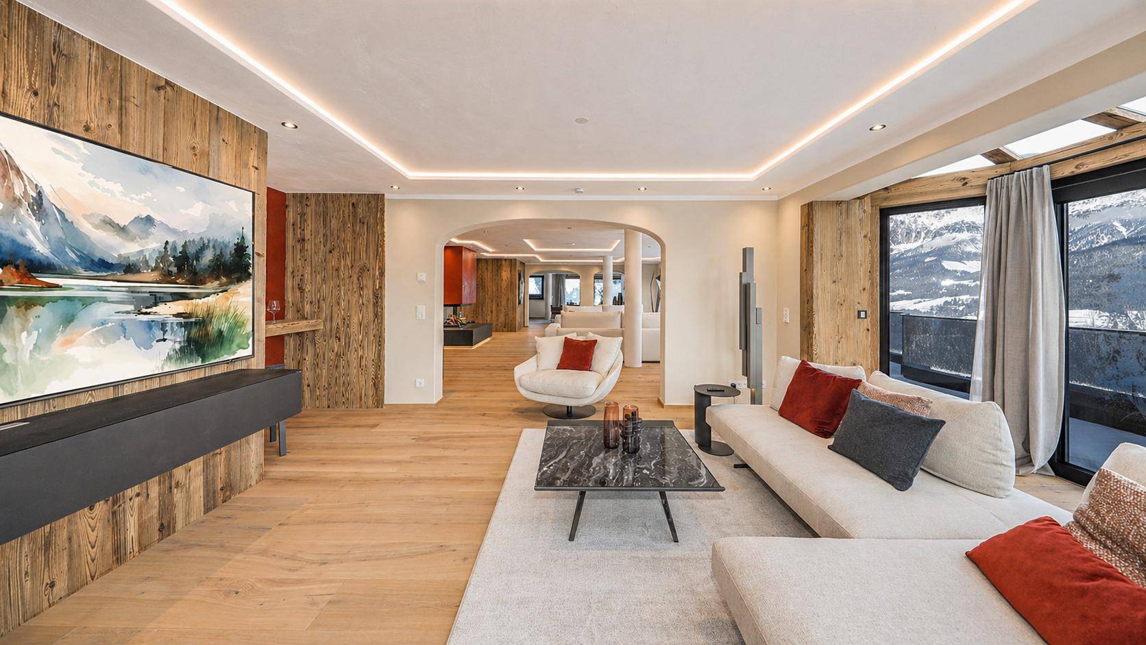 Helles Wohnzimmer mit Holzwand, großem Sofa und Blick auf die verschneite Landschaft.