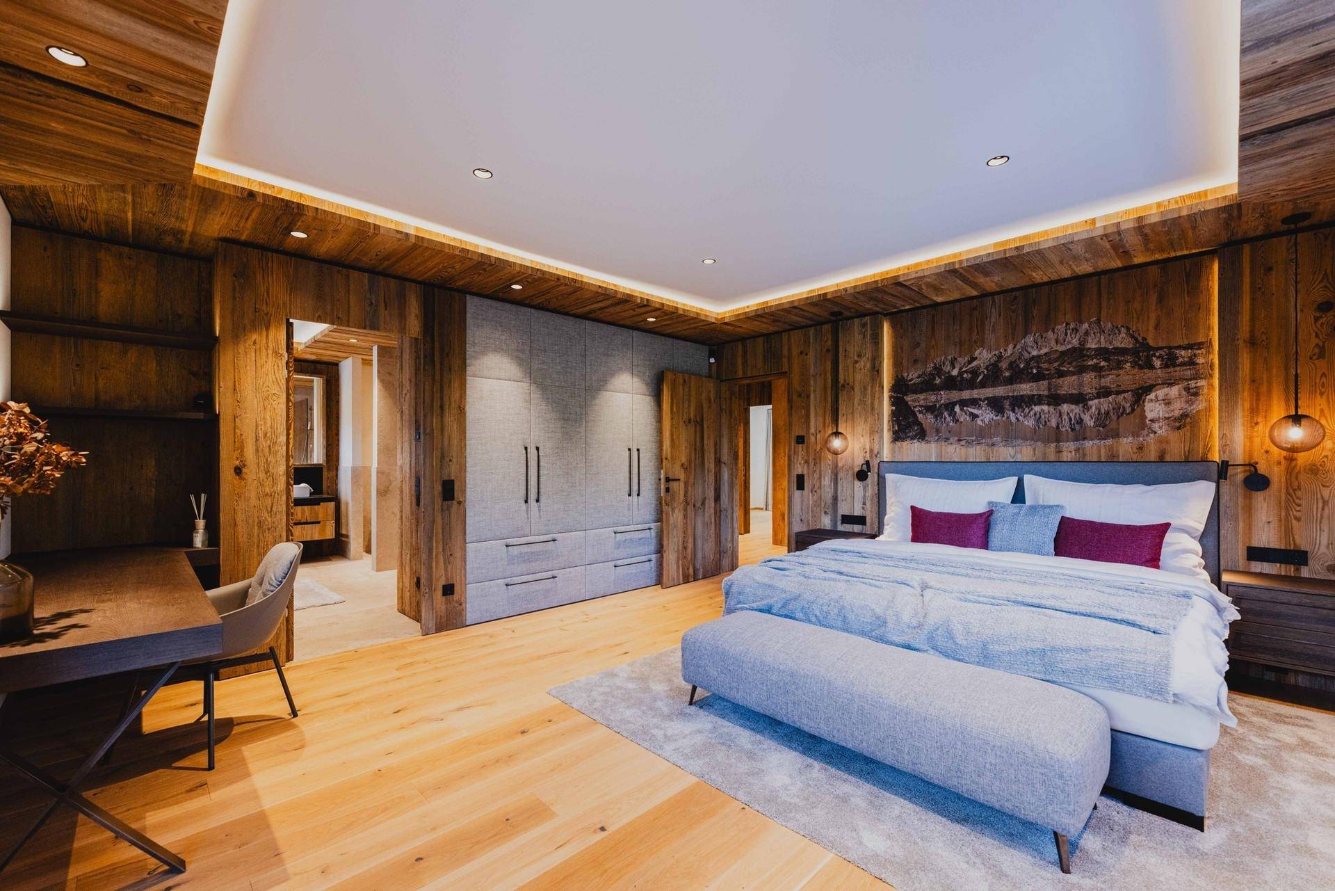 Geräumiges Schlafzimmer mit Holzwänden, Einbauschränken und gemütlichem Doppelbett.