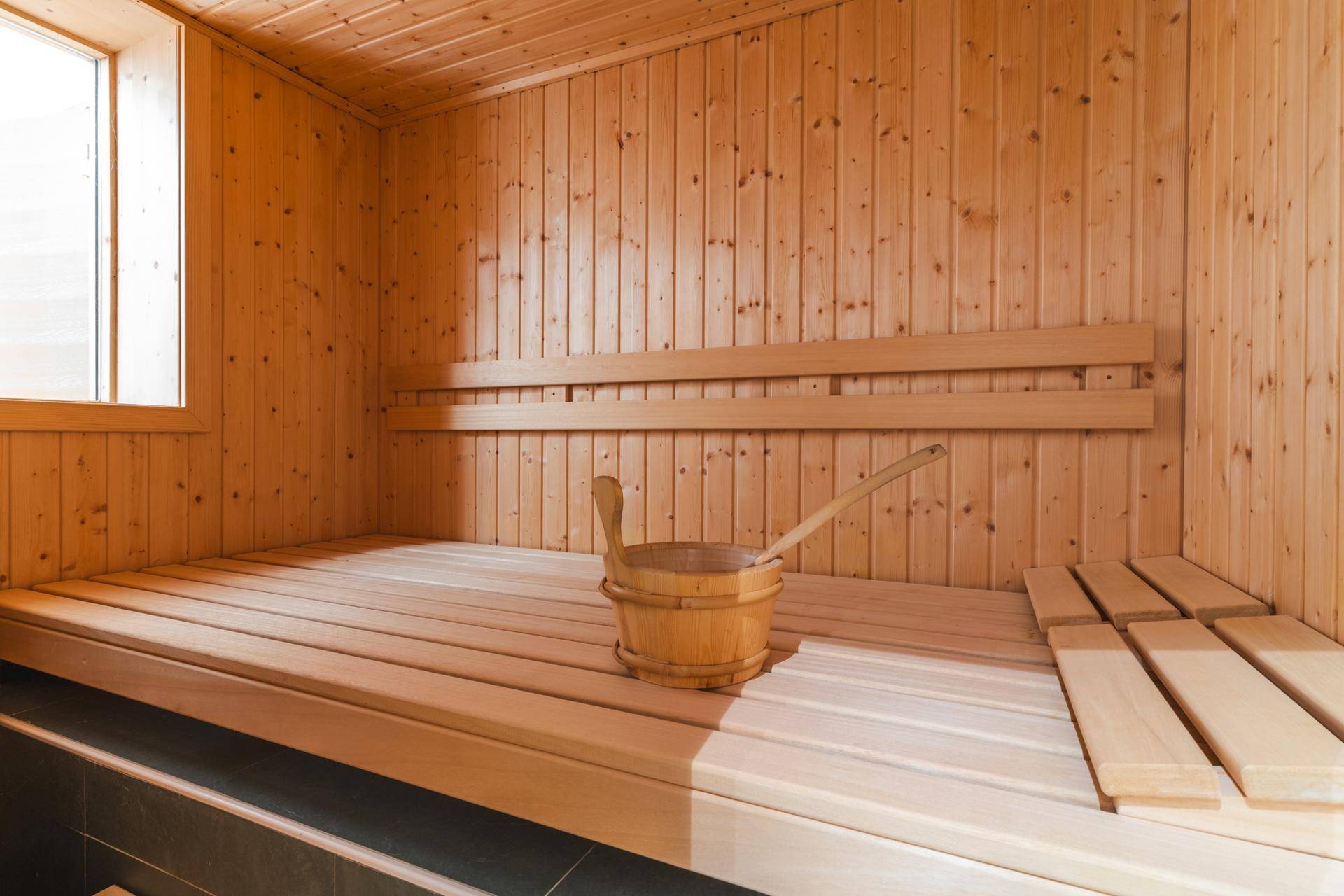 Private Sauna mit Holzbänken und traditionellem Saunaeimer, ideal zur Entspannung.