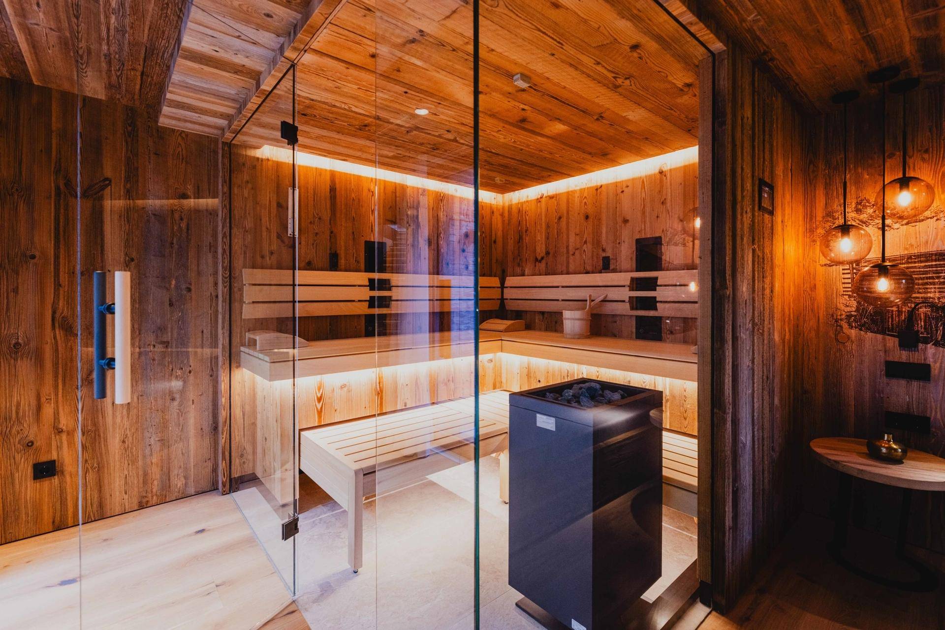Moderne Holzsauna mit Glasfront, bequemen Bänken und stimmungsvoller Beleuchtung für Entspannung.