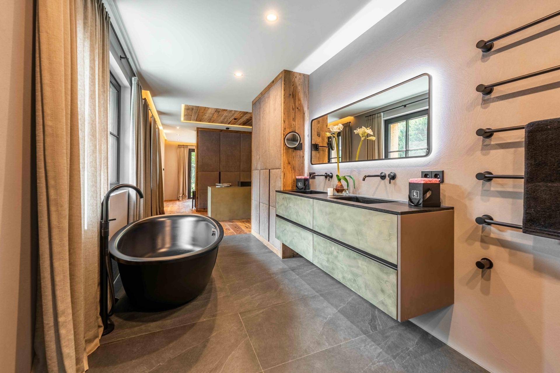 Elegantes Badezimmer mit freistehender Badewanne, Doppelwaschbecken und beheiztem Handtuchhalter.