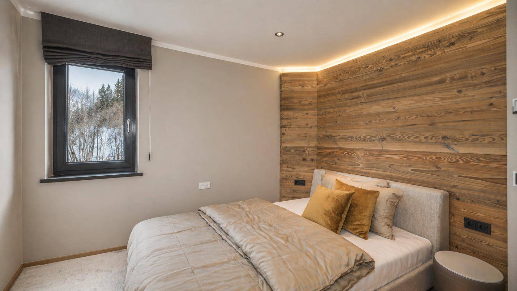 Gemütliches Schlafzimmer mit Holzwand, Doppelbett und Fenster mit Blick ins Grüne.