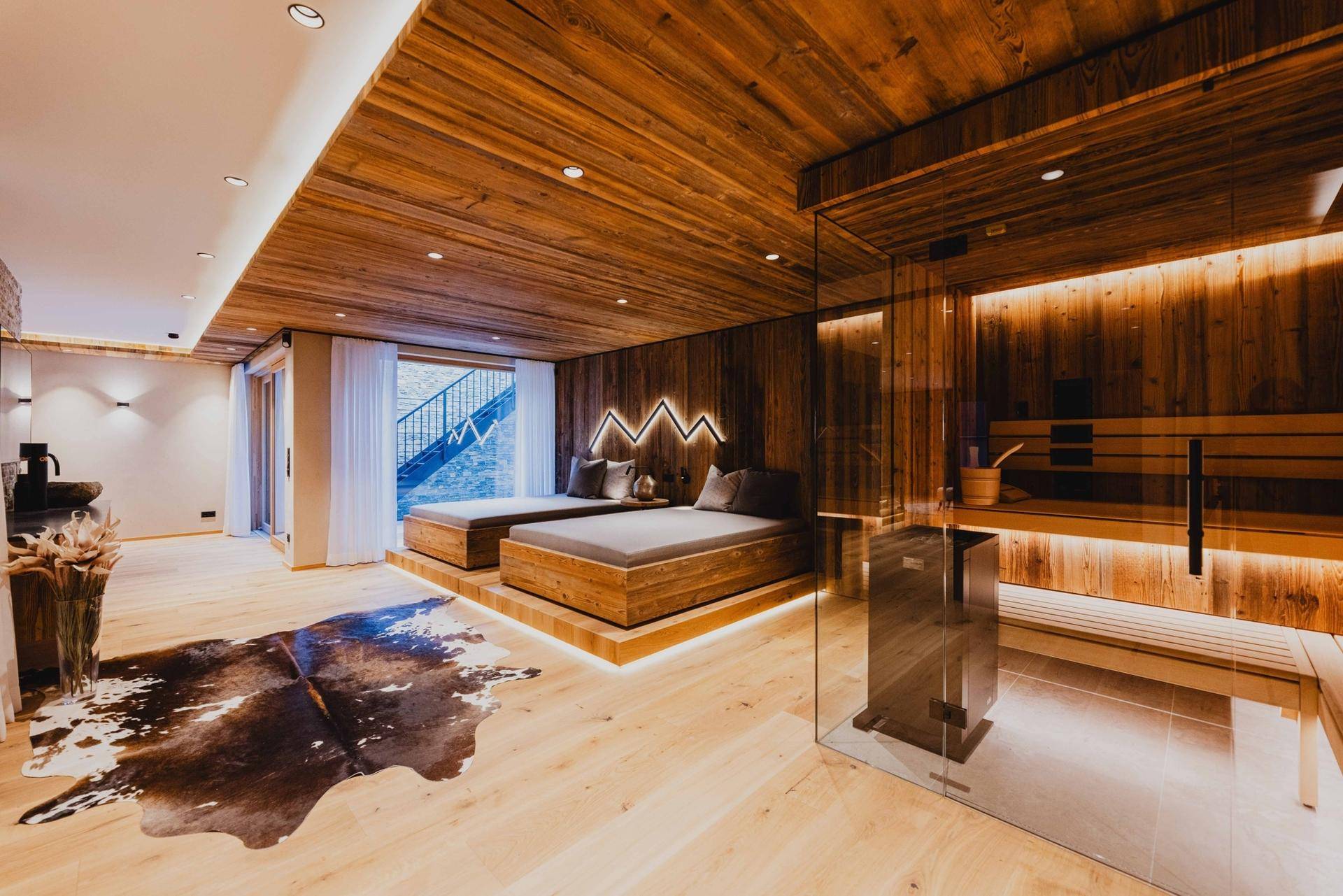 Geräumiger Wellnessbereich mit Sauna, Holzdecken und Liegebetten für Entspannung.