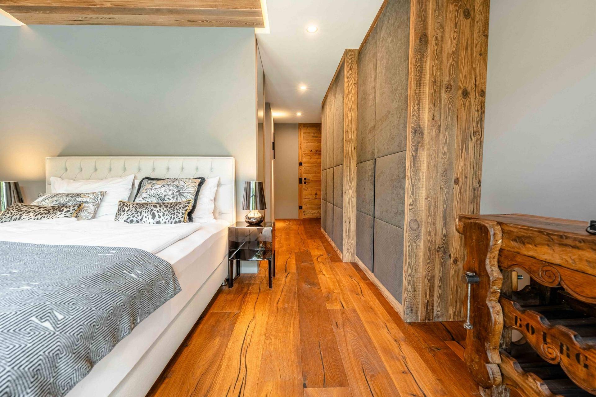 Elegantes Schlafzimmer mit Holzboden und integrierten Schränken, die eine warme Atmosphäre schaffen.