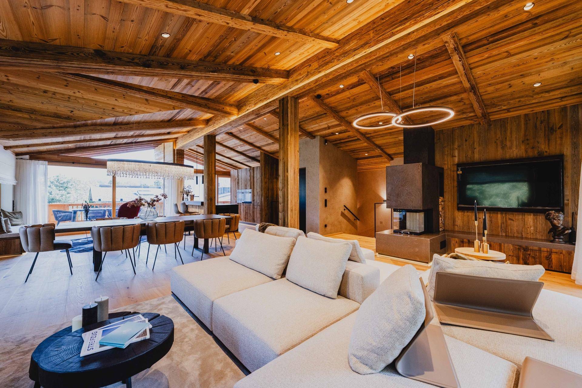 Luxuriöser Wohnbereich mit Kamin, bequemen Sofas und Blick auf den Essbereich.