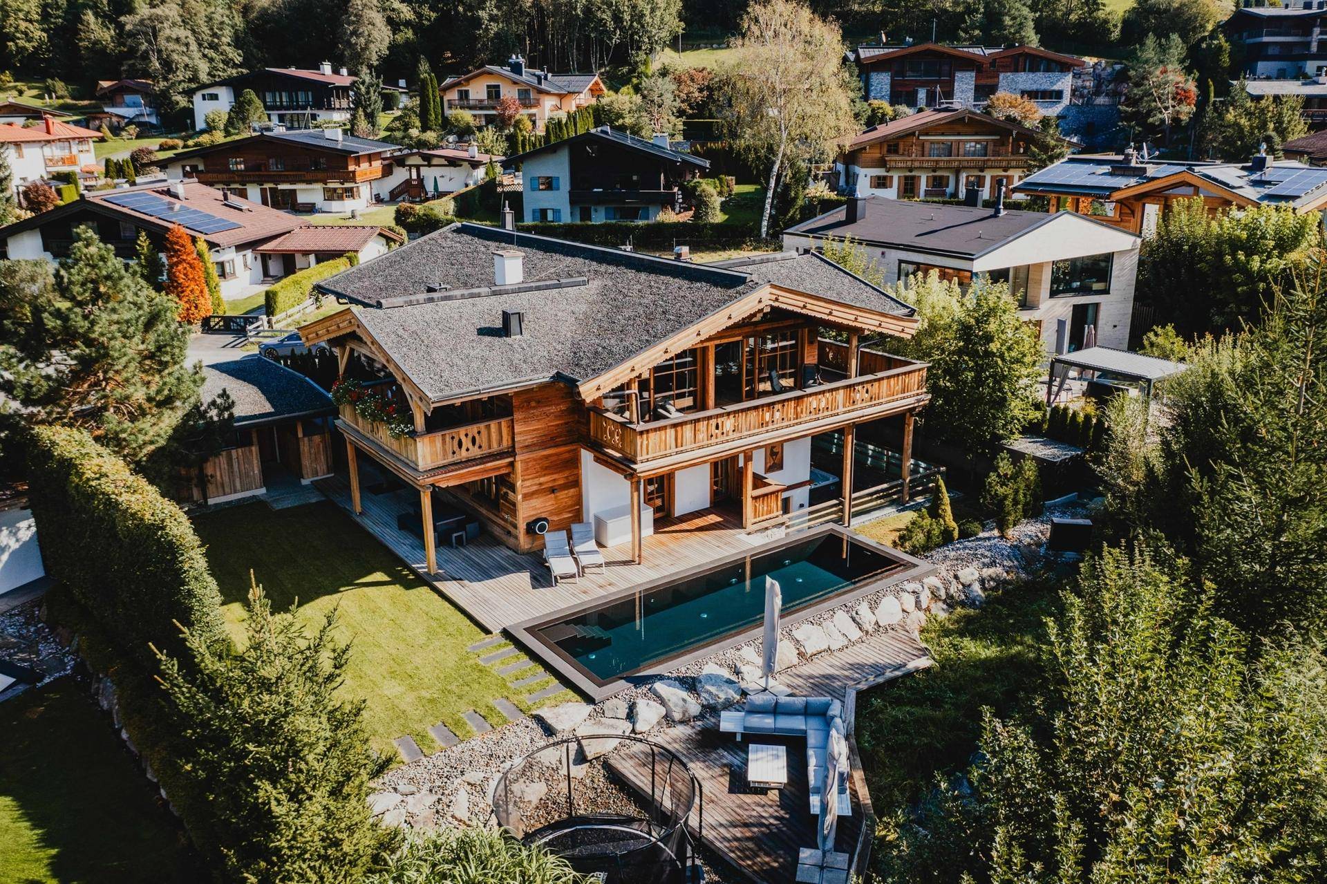 Weitläufige Ansicht eines exklusiven Chalets mit Pool und gepflegter Außenanlage in sonniger Lage.