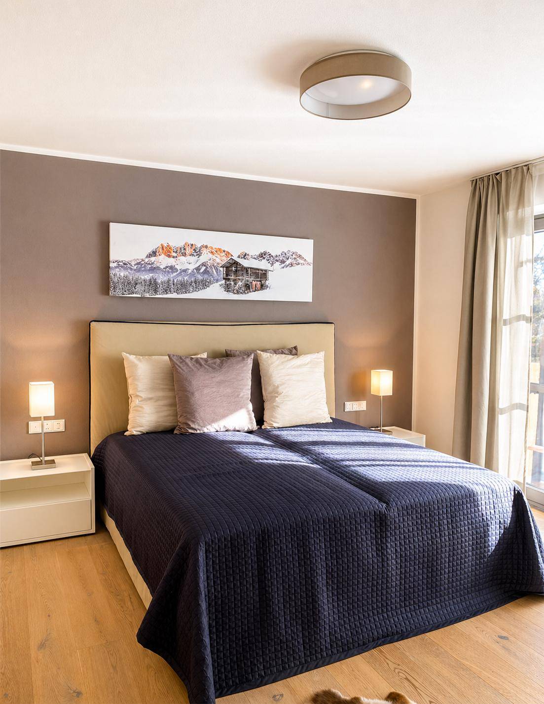 Gemütliches Schlafzimmer mit Doppelbett, Holzboden und einem Fenster mit Blick ins Grüne.