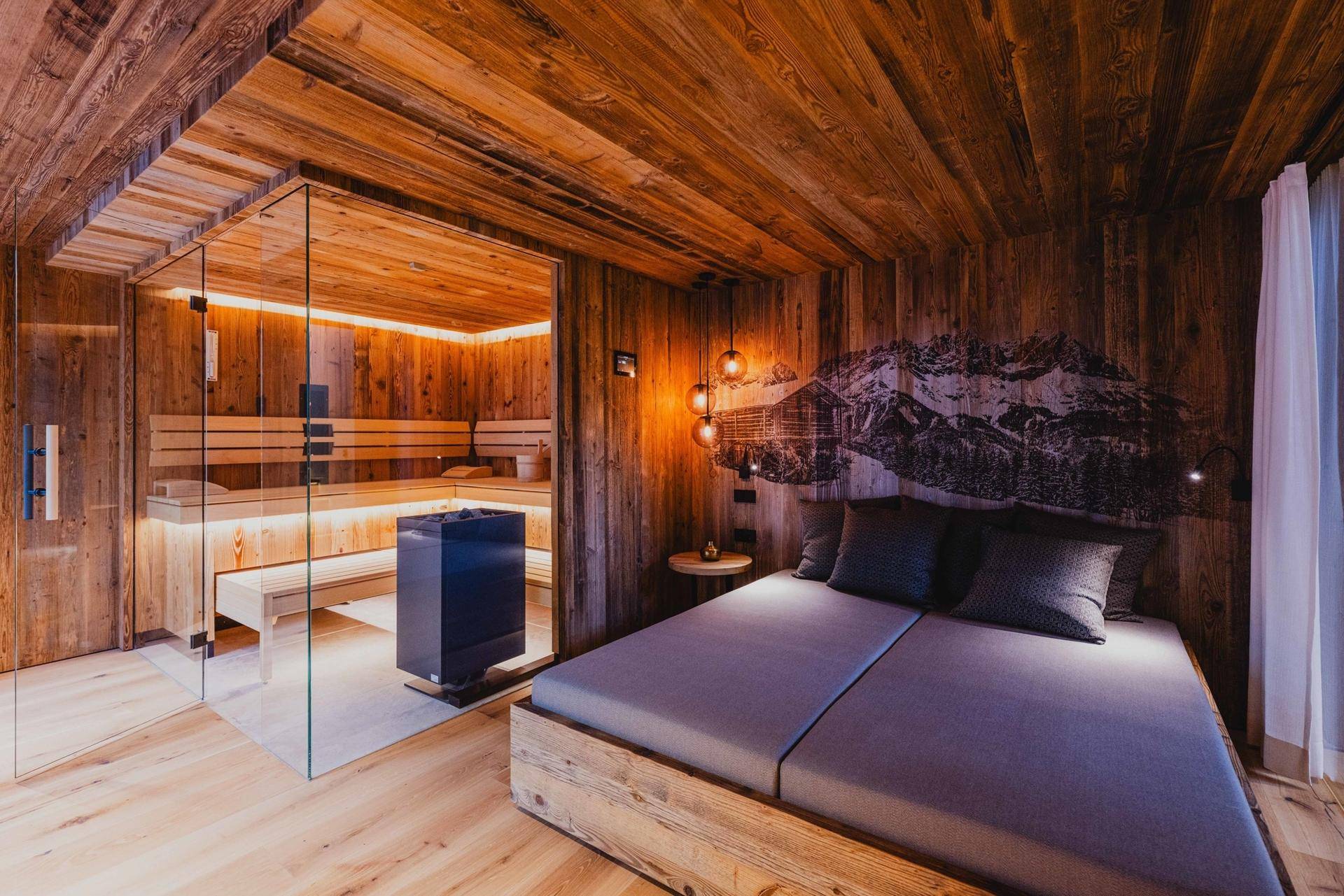 Gemütliches Schlafzimmer mit Holzwänden, Doppelbett und einer integrierten Sauna für Wellness.
