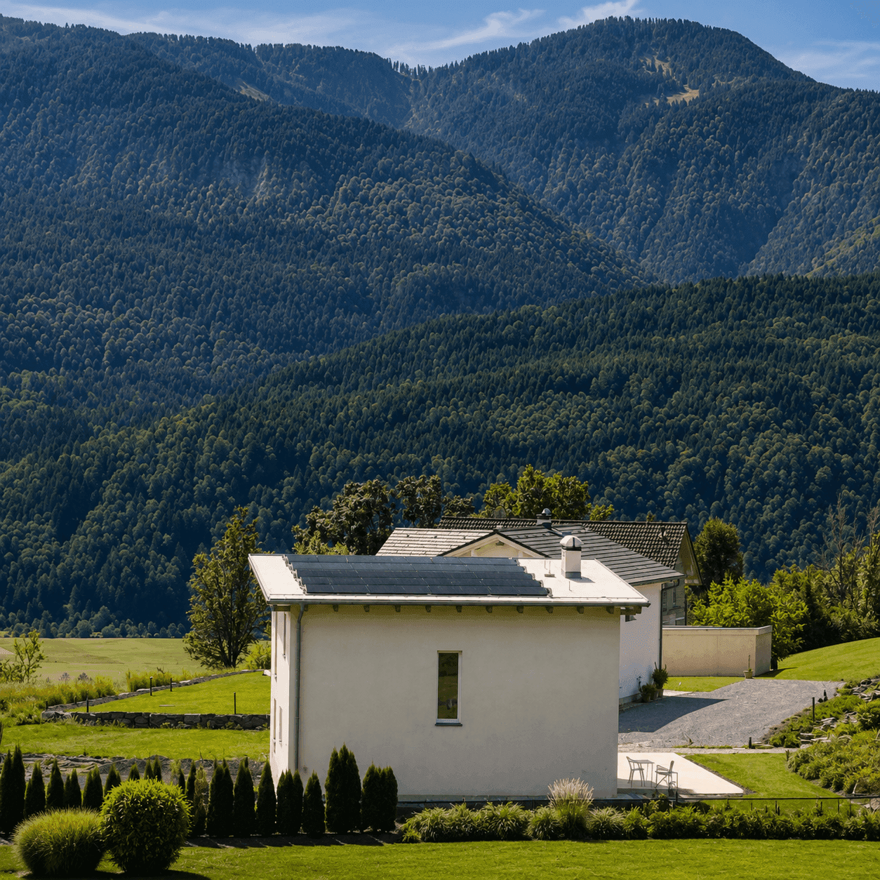 Modernes Wohnhaus mit Photovoltaikanlage auf dem Dach, eingebettet in eine grüne Hügellandschaft.