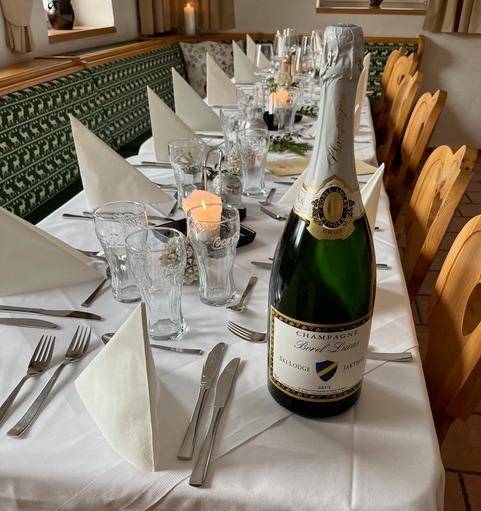 Festlich gedeckter Esstisch mit Champagnerflasche in einem traditionellen Speisesaal.