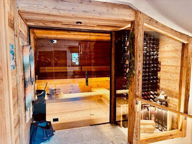 Exklusiver Wellnessbereich mit Sauna und integriertem Weinkeller, umgeben von warmem Holz.