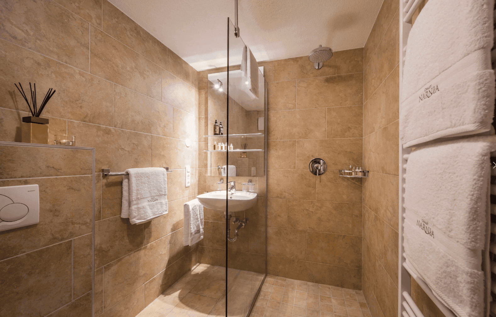 Modernes Badezimmer mit ebenerdiger Dusche, Einzelwaschbecken und beheiztem Handtuchhalter.